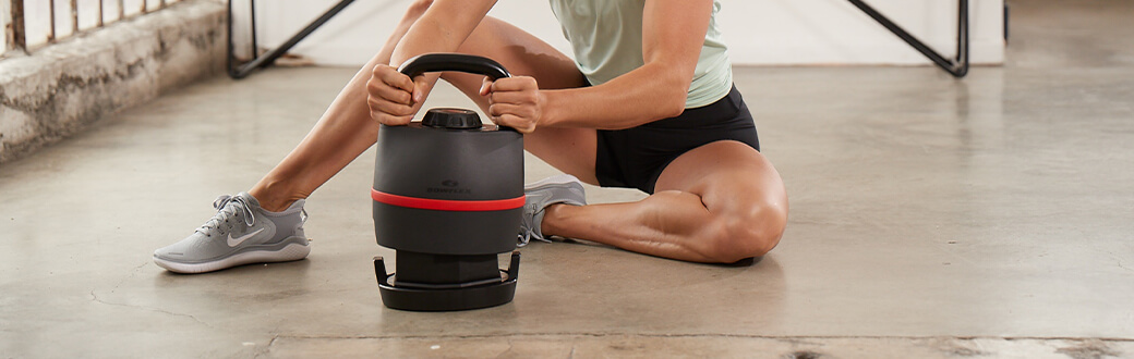 A fit man using a Bowflex SelectTech 840 Kettlebell.