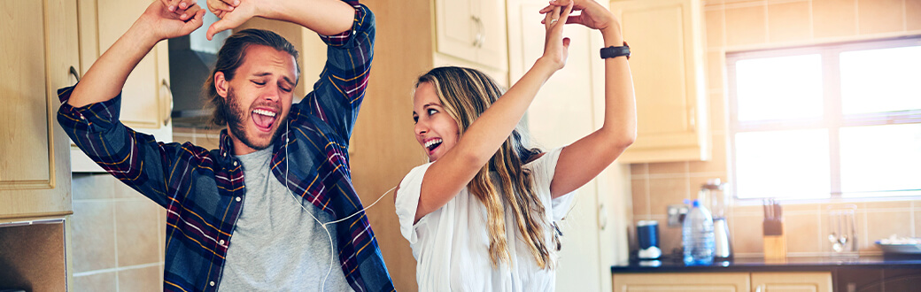 Two people dancing in a kitchen.