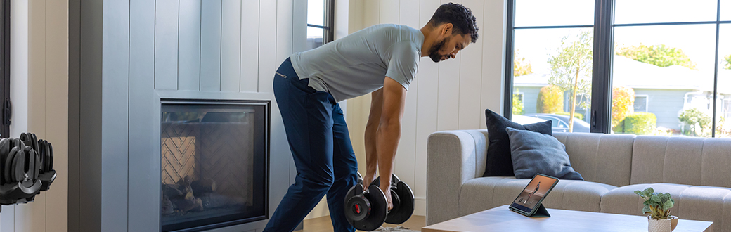 Doing a dumbbell strength workout in a living room