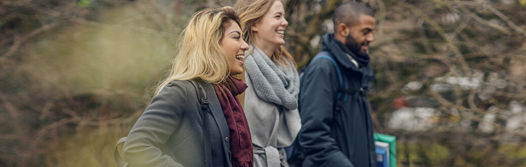 Three people walking outside.