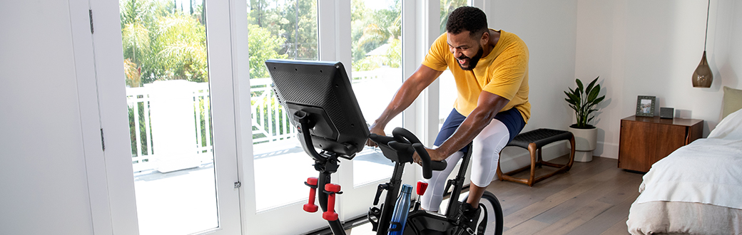 A man working out on a Bowflex VeloCore exercise bike.