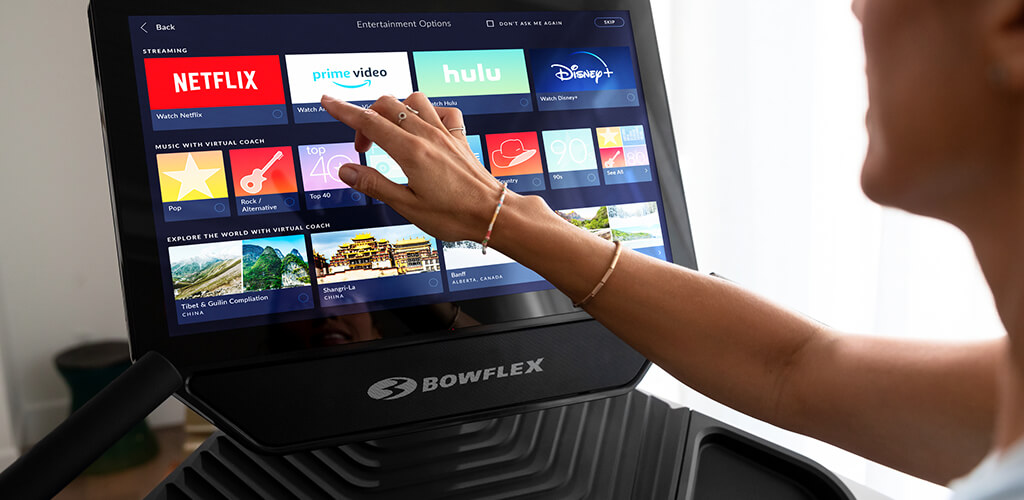 A person interacting with the Treadmill 22 touchscreen.