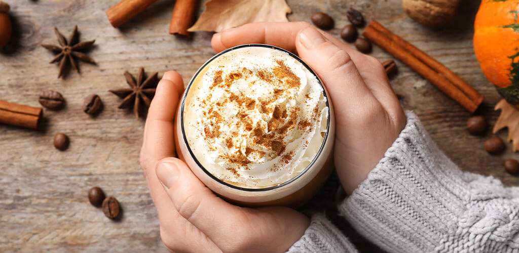 A cup of pumpkin spice latte on a wooden table.