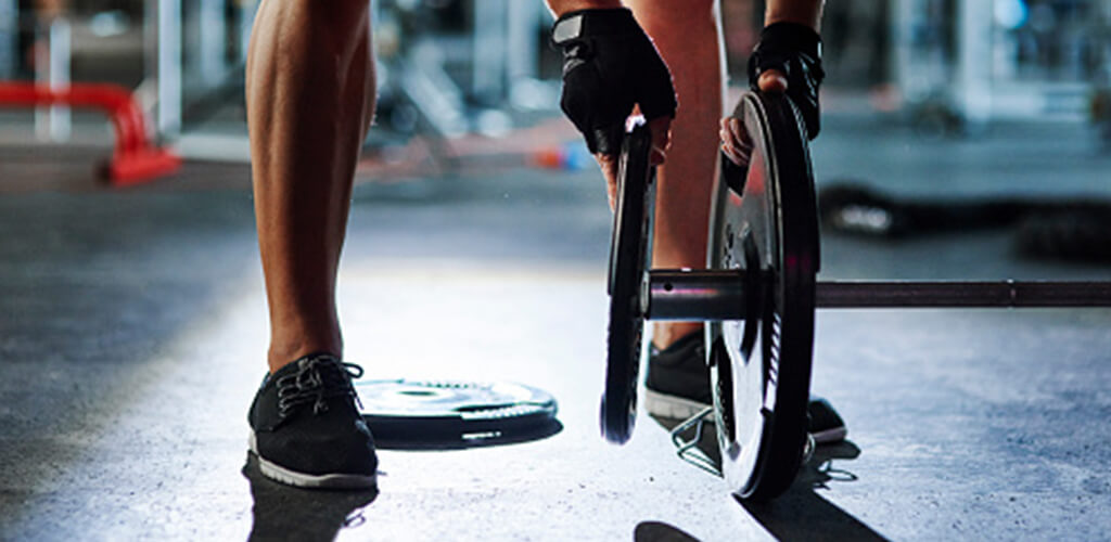 A person adding weight to a barbell.