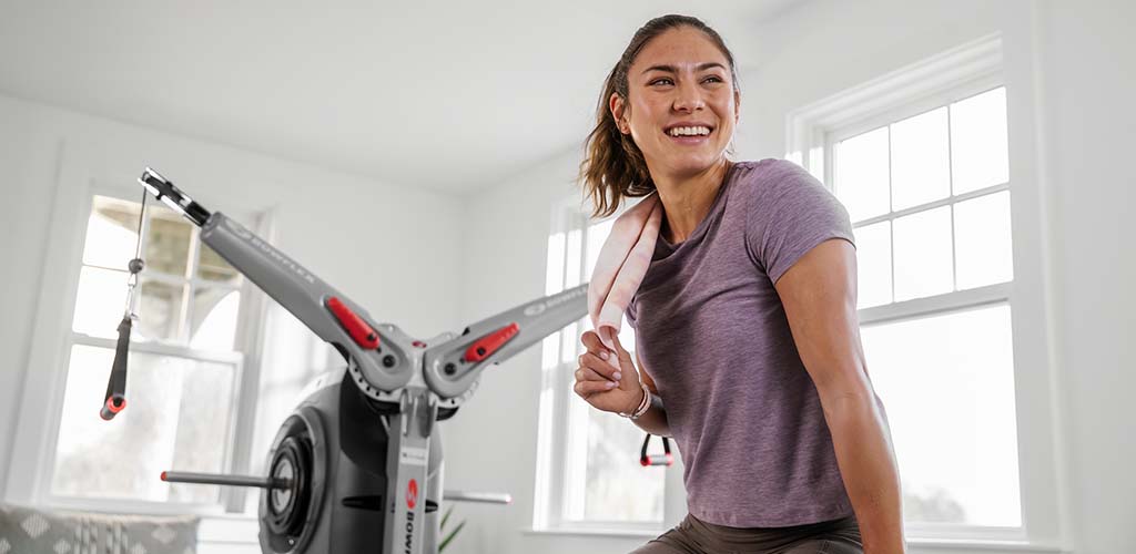 A woman sitting on a Bowflex Revolution.