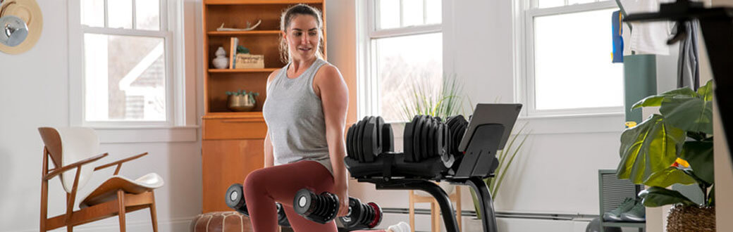 A woman performing a dumbbell front lunge.