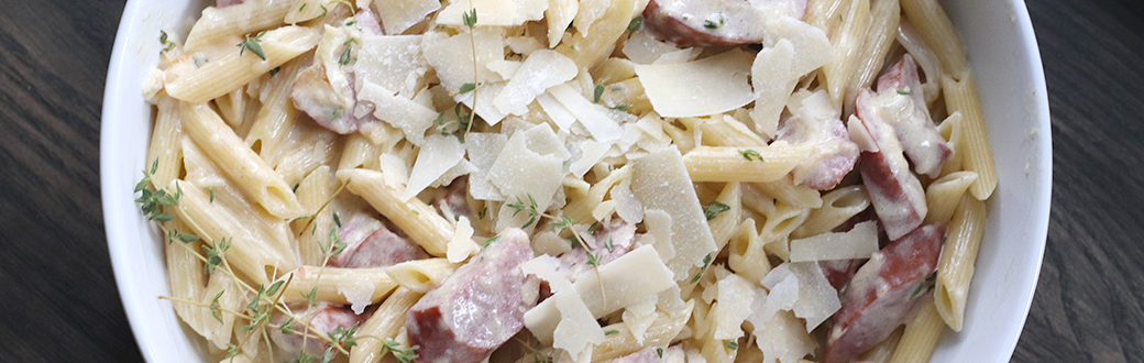 Kielbasa penne pasta topped with freshly grated Parmesan