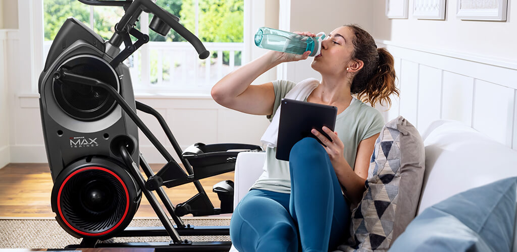 A woman next to a Max Trainer.