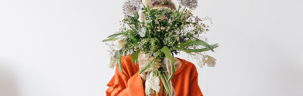 A woman holding a large bouquet of flowers.