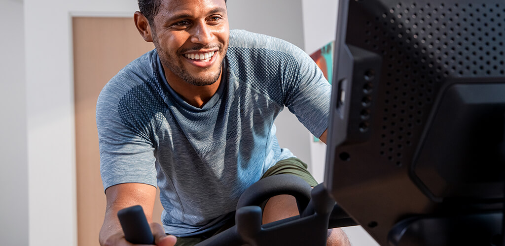 A man working out on a Bowflex VeloCore bike.