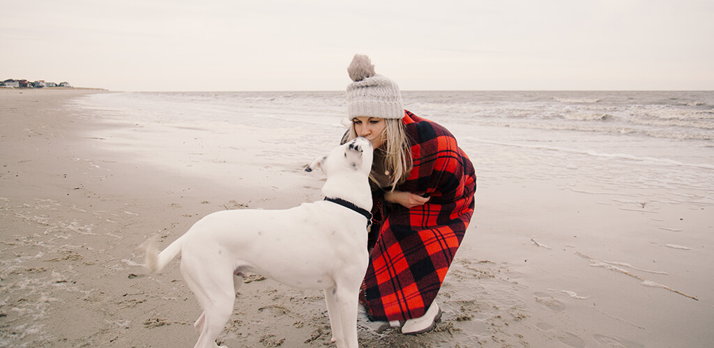 A woman on the beach with her dog