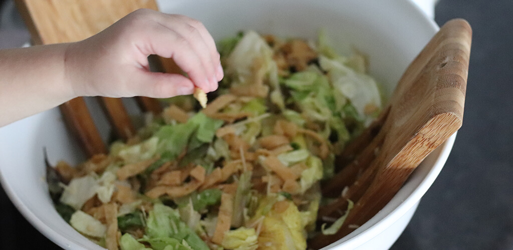 a child eating caesar salad.