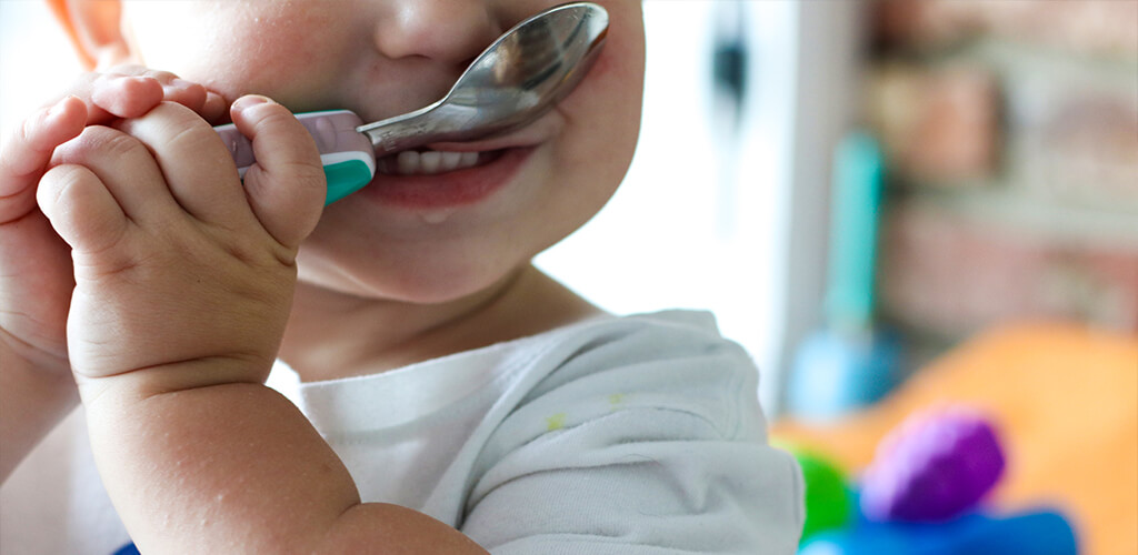 A young child with a spoon.