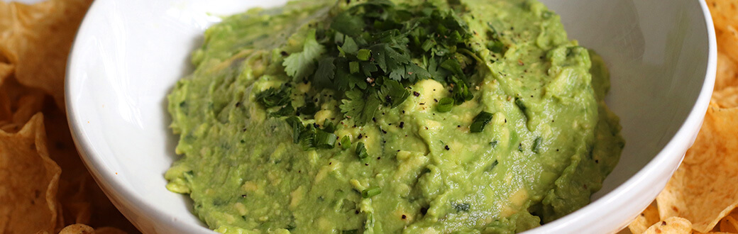 Prepared guacamole in a white bowl.