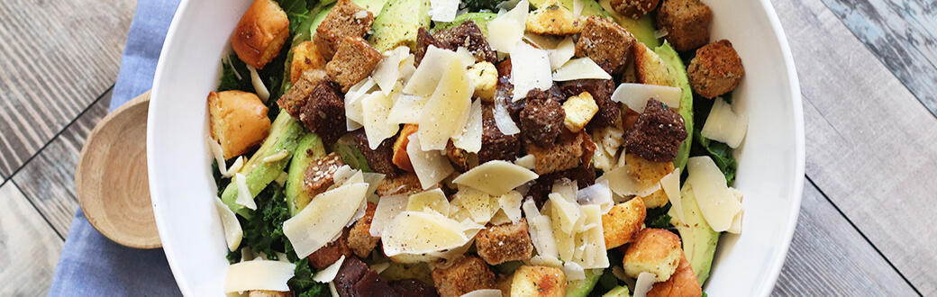 Kale and avocado caesar salad in a bowl.