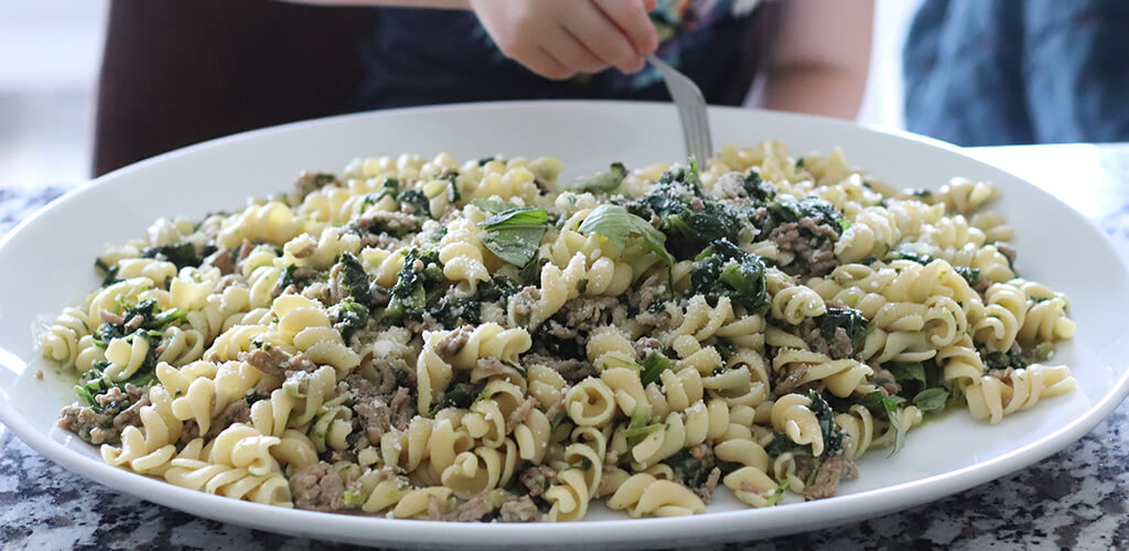 kale and sauage pasta on a serving dish.