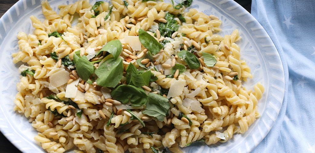 Lemon arugula pasta salad in a aserving dish.