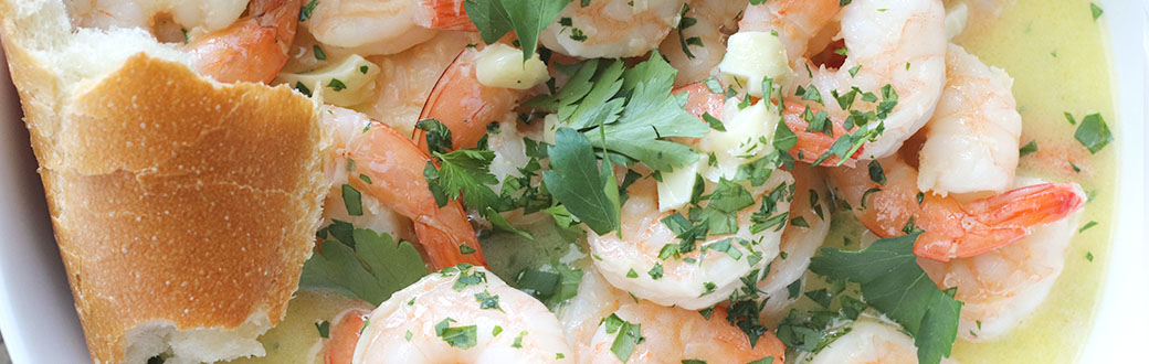 Shrimp scampi and bread on a serving dish.