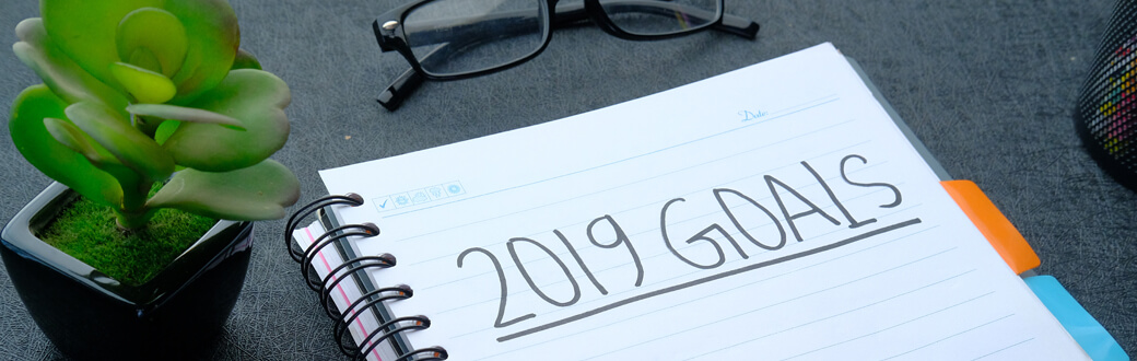 A pad of paper on a table with "2019 Goals" written on it.