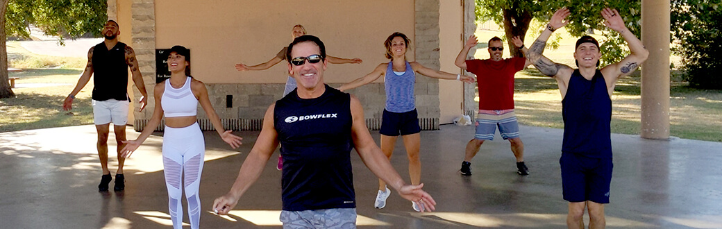 Smiling people doing jumping jacks