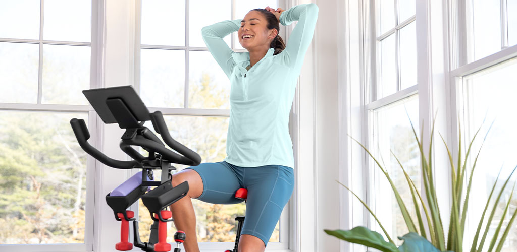 A woman using a Bowflex Bike.