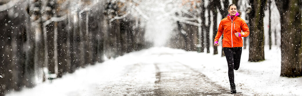 A woman running on a snowy road.