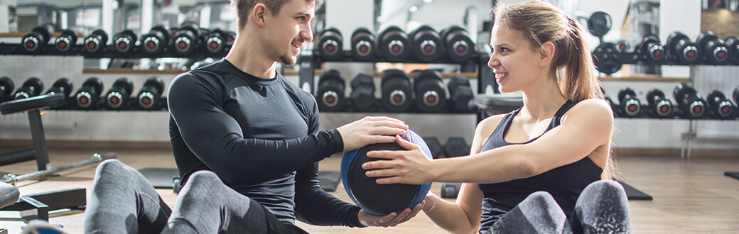 Two people in a gym performing a partner workout